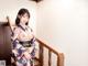 A woman in a kimono is posing on the stairs.