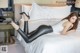 A woman laying on a bed wearing black leather pants and high heels.