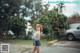 A woman standing in the middle of a parking lot.