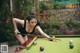 A woman leaning over a pool table with a cue.