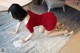 A woman in a red dress is cleaning the floor.