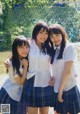 A group of three young women standing next to each other.