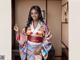 A woman in a colorful kimono posing for a picture.