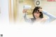 A woman blow drying her hair in front of a mirror.